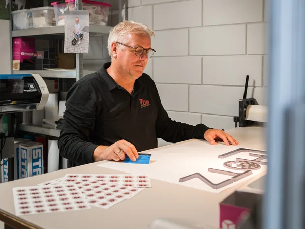Erik maakt stickers op maat aan de werkbank